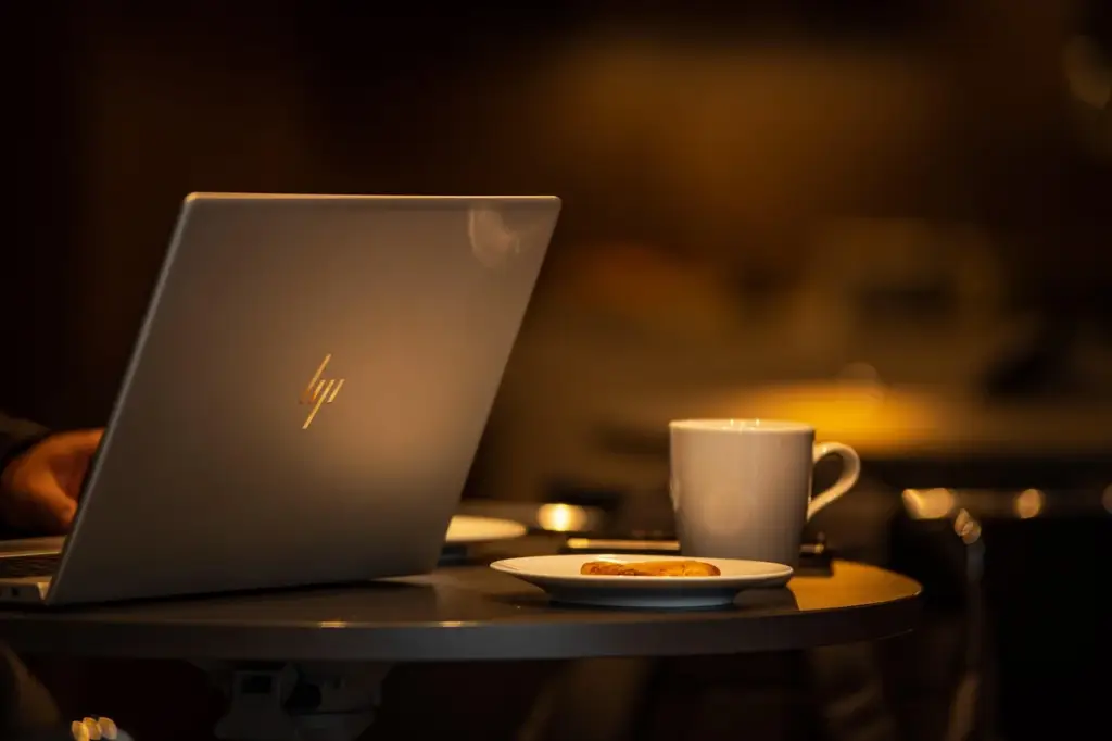 Laptop showing a comparison of 0% APR card options while drinking coffee at a cafe