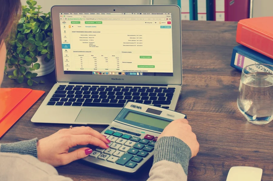 Laptop and calculator used to calculate monthly payments for a 0% APR balance payoff plan