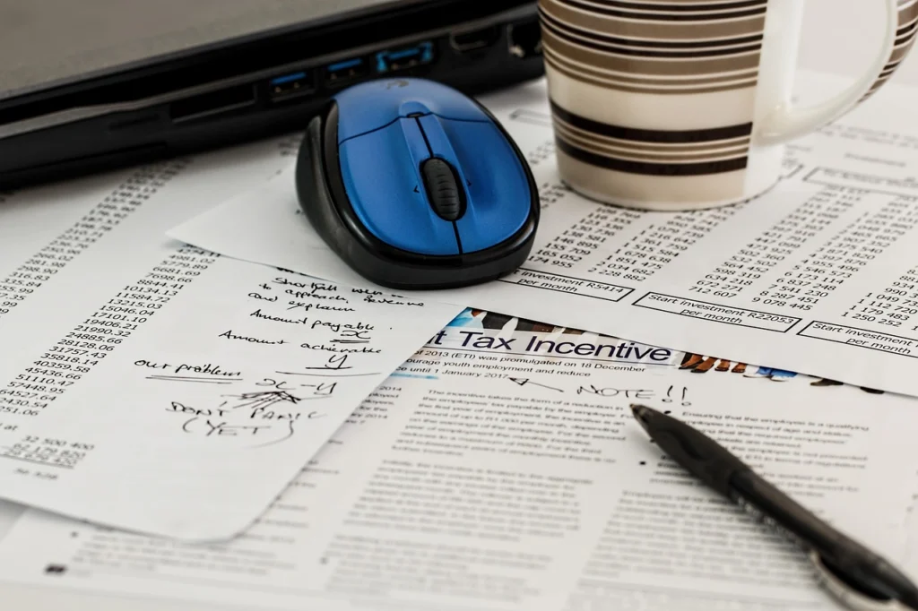 Person calculating finances with a calculator and credit card statements to compare 0% APR offers